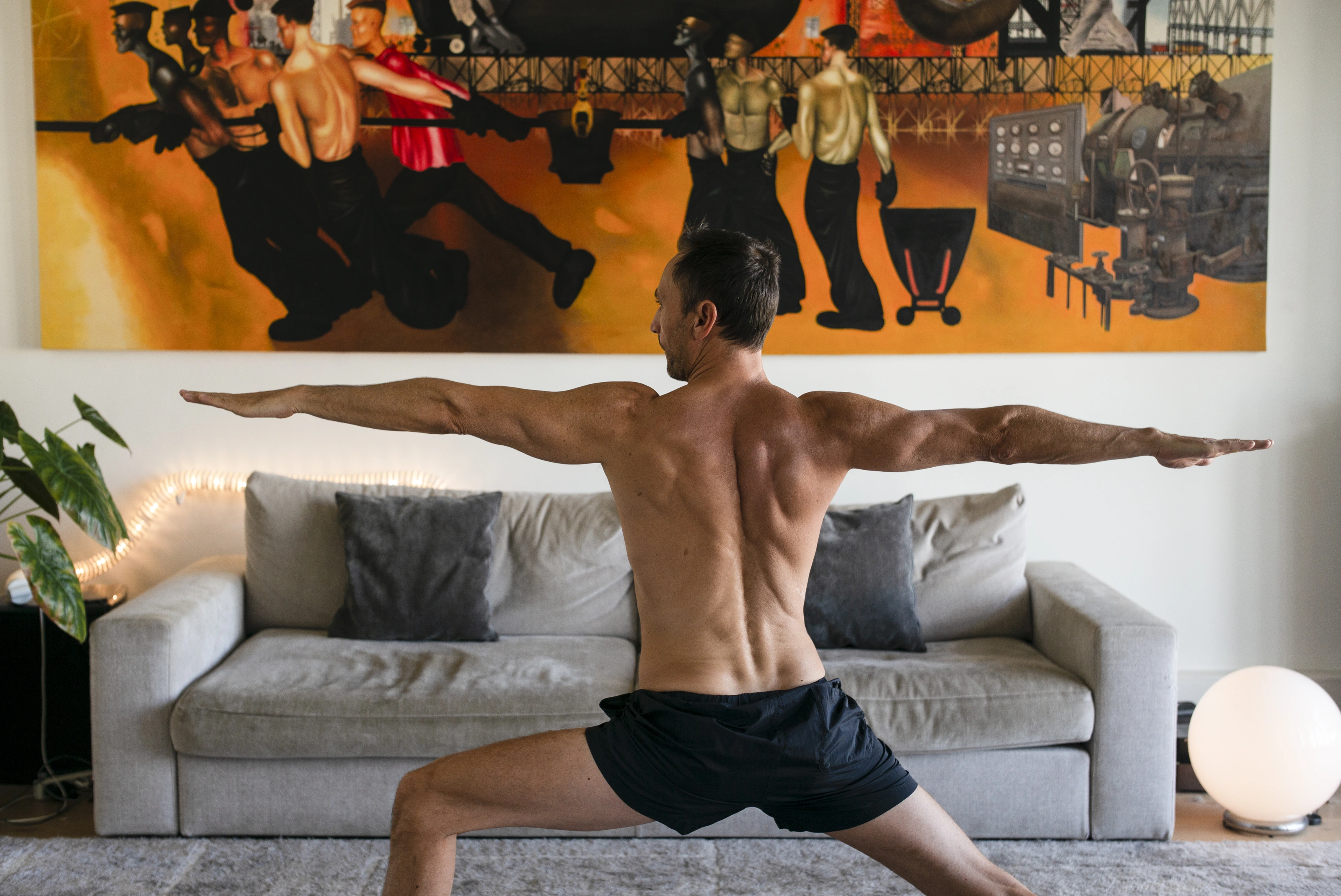 John-Oliver Breckoff practising a standing yoga posture in his home